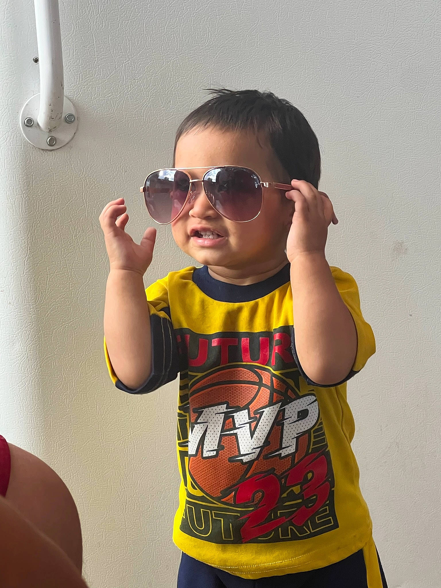 Diego is registered to the contest to win money with this photo: baby_toddler_clothing, chest, child, elbow, eyewear, facial_expression, finger, fun, gesture, glasses, goggles, happy, person, personal_protective_equipment, sleeve, sunglasses, t_shirt, thumb, toddler, vision_care