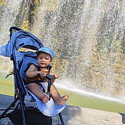 Mylane a rejoint le concours — aidez-le/la à gagner de superbes lots ! accessories, baby, backpack, bag, clothing, face, hat, head, nature, outdoors, person, photography, plant, portrait, rock, stroller, summer, vegetation, water, waterfall