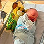 Isaiah joined the competition — help win amazing prizes! newborn, baby, hospital, bassinet, swaddled, plush_toy, simba, sleeping, infant, blanket, soft_lighting, cute, child, bed, maternity, resting, wrapped, person, toy, cozy