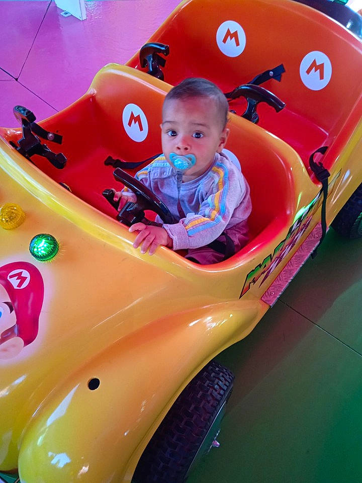 Kyllian participe au concours pour gagner de l'argent avec cette photo : automotive_design, automotive_exterior, automotive_tire, automotive_wheel_system, bumper, car, fender, fun, helmet, hood, kit_car, motor_vehicle, motorsport, person, pink, racing, riding_toy, surprise, tire, toddler