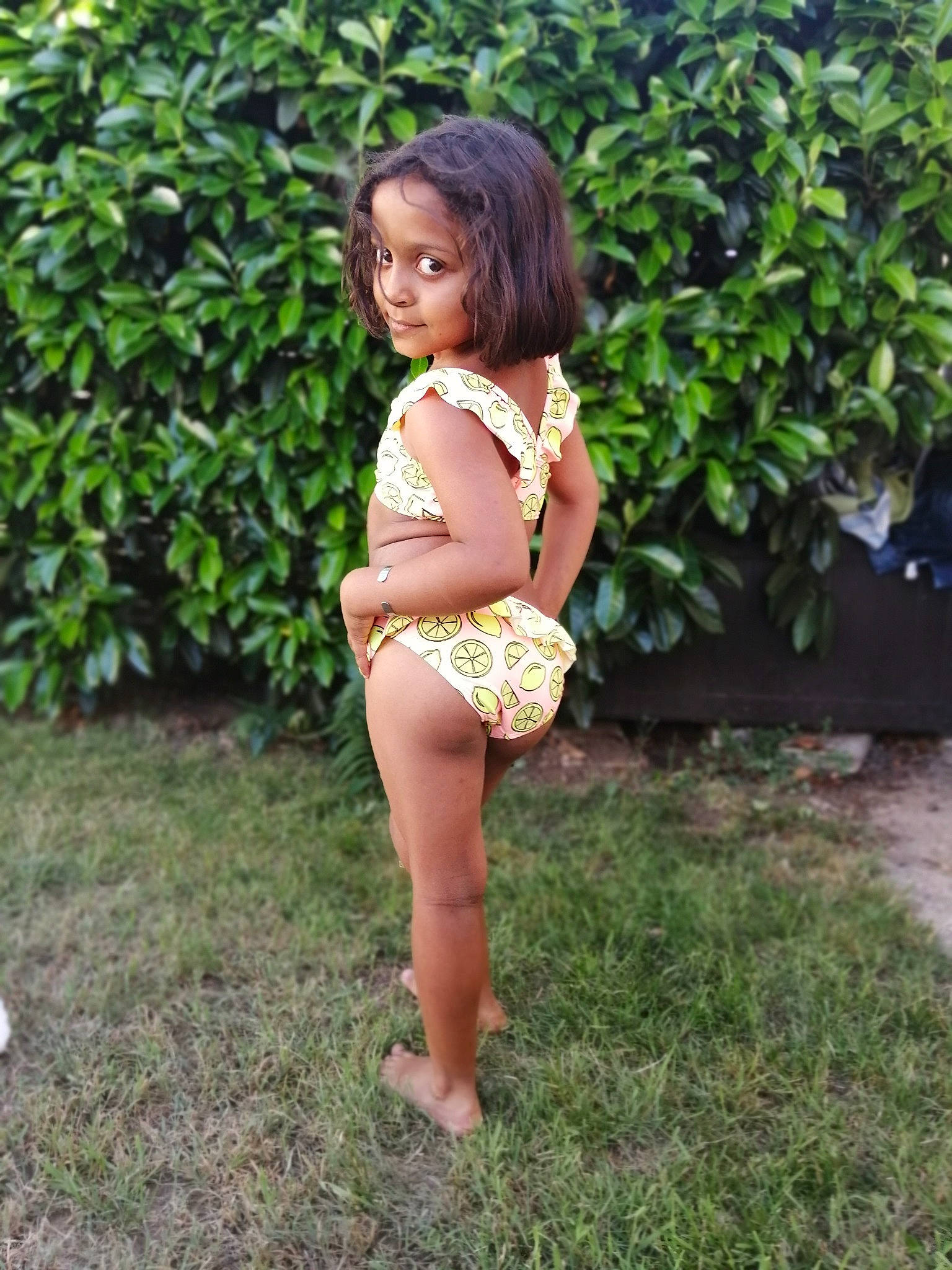 Kenzy participe au concours pour gagner de l'argent avec cette photo : barefoot, beauty, black_hair, child, child_model, clothing, fawn, grass, human_leg, leg, long_hair, person, photo_shoot, plant, sitting, summer, thigh, toddler