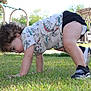 toddler, child, grass, outdoor, playground, shoes, curly_hair, dinosaur_shirt, shorts, sunny_day, park, exploring, crawling, play_equipment, bench, tree, person, nature, summer, fun