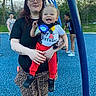Carson is registered to the contest to win money with this photo: adult, birthday, blue, casual, celebration, child, family, fence, glasses, grass, happy, outdoor, pants, person, playground, smile, sneakers, swing, tattoo, tree