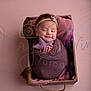 Ailany is registered to the contest to win money with this photo: newborn, baby, wrapped, purple_blanket, wooden_box, knitted_star, headband, smiling, sleeping, pink_background, portrait, infant, cozy, cute, hands, soft_lighting, studio_photo, child, peaceful, resting