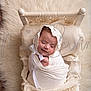 baby, sleeping, wrapped, white_cloth, lace_bonnet, woven_bed, fluffy_rug, cream_color, peaceful, newborn, infant, portrait, cozy, soft_texture, cute, child, resting, indoors, head, hands