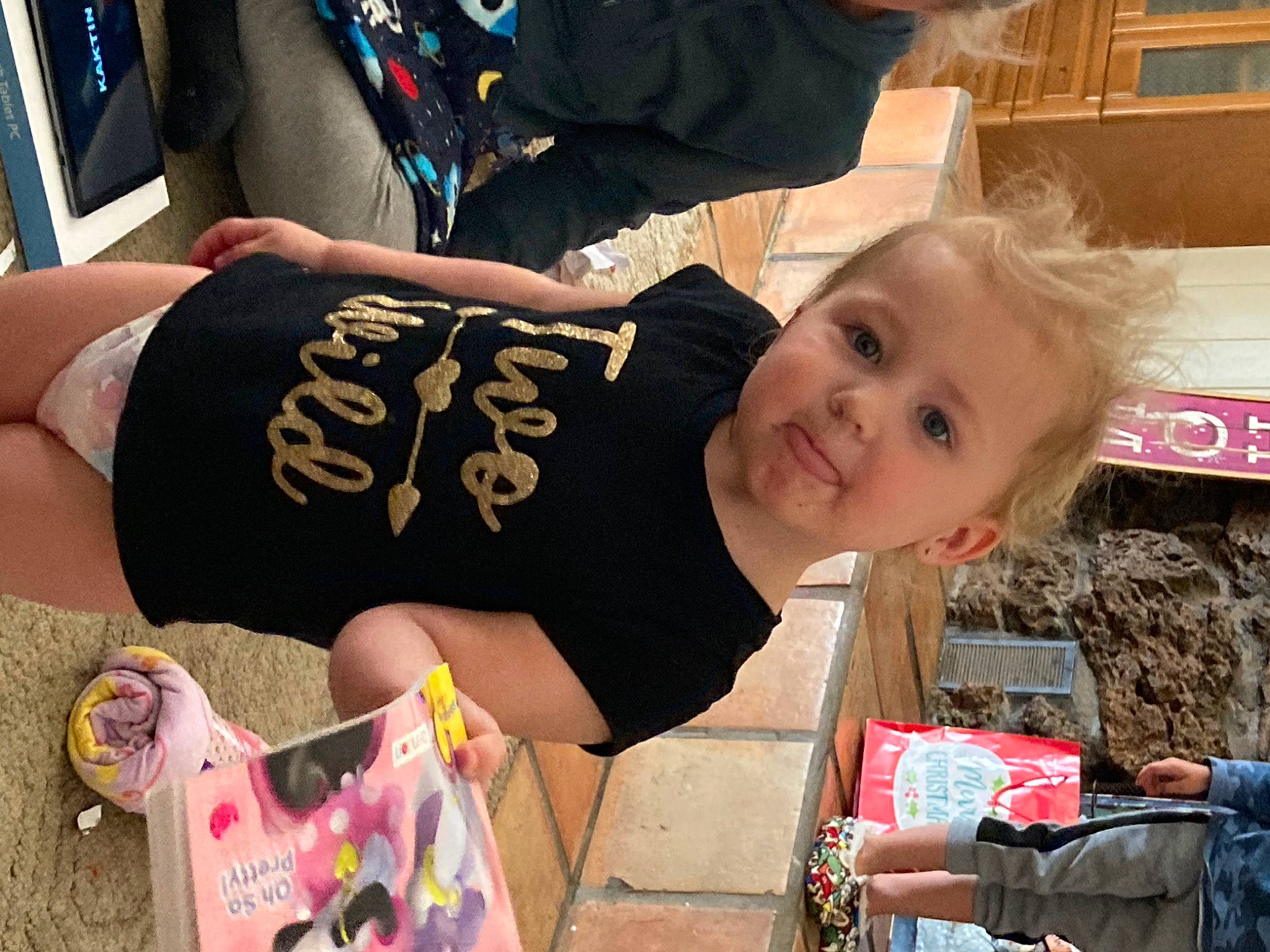 Emma is registered to the contest to win money with this photo: child, elbow, event, fun, happy, holiday, pattern, person, play, smile, t_shirt, thigh, toddler, tree, window, wrist