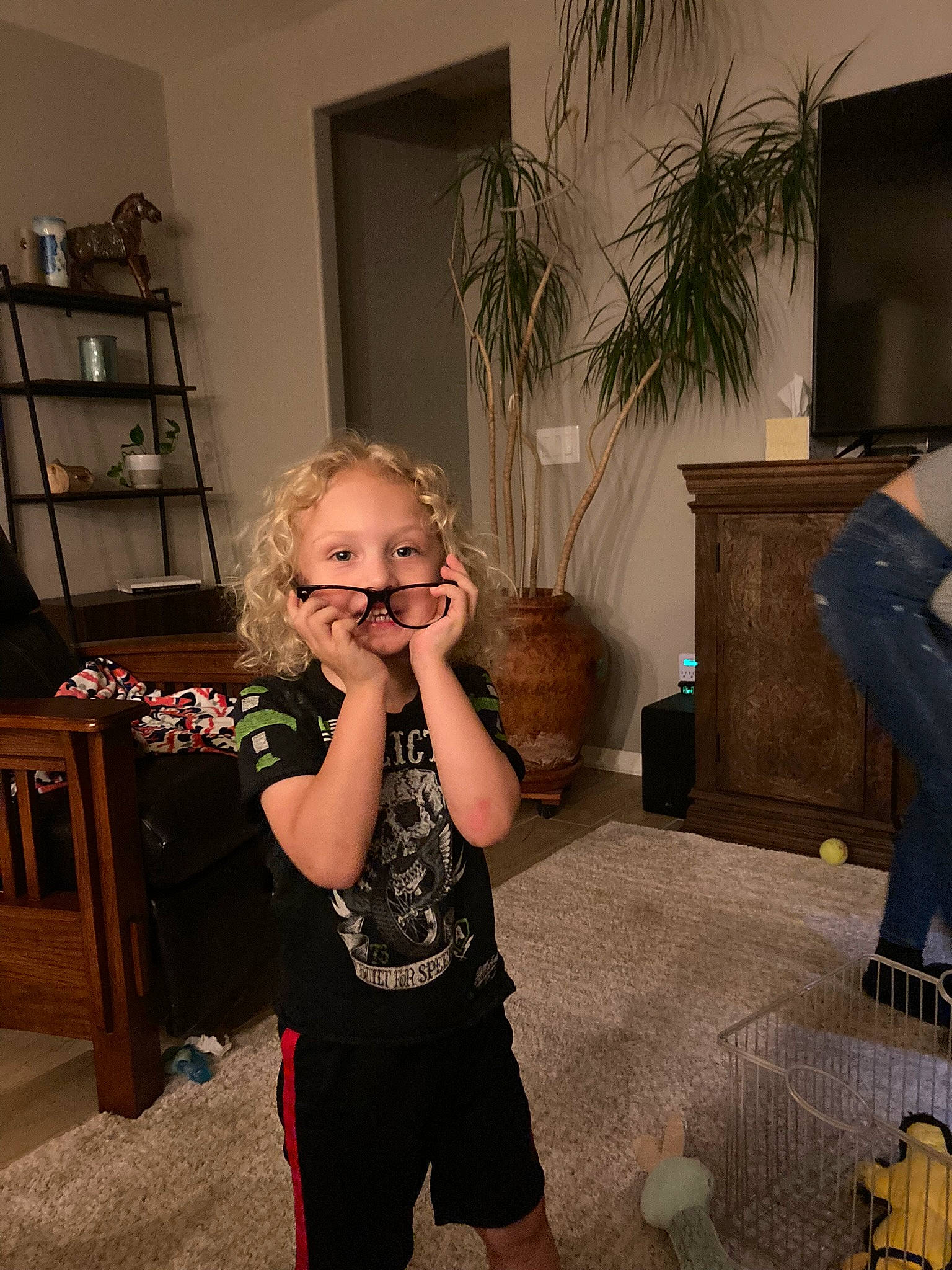 Jackie is registered to the contest to win money with this photo: abdomen, black, drawer, flooring, fun, happy, hardwood, holiday, home, houseplant, living_room, person, plant, room, sitting, smile, standing, toddler, tree, trunk