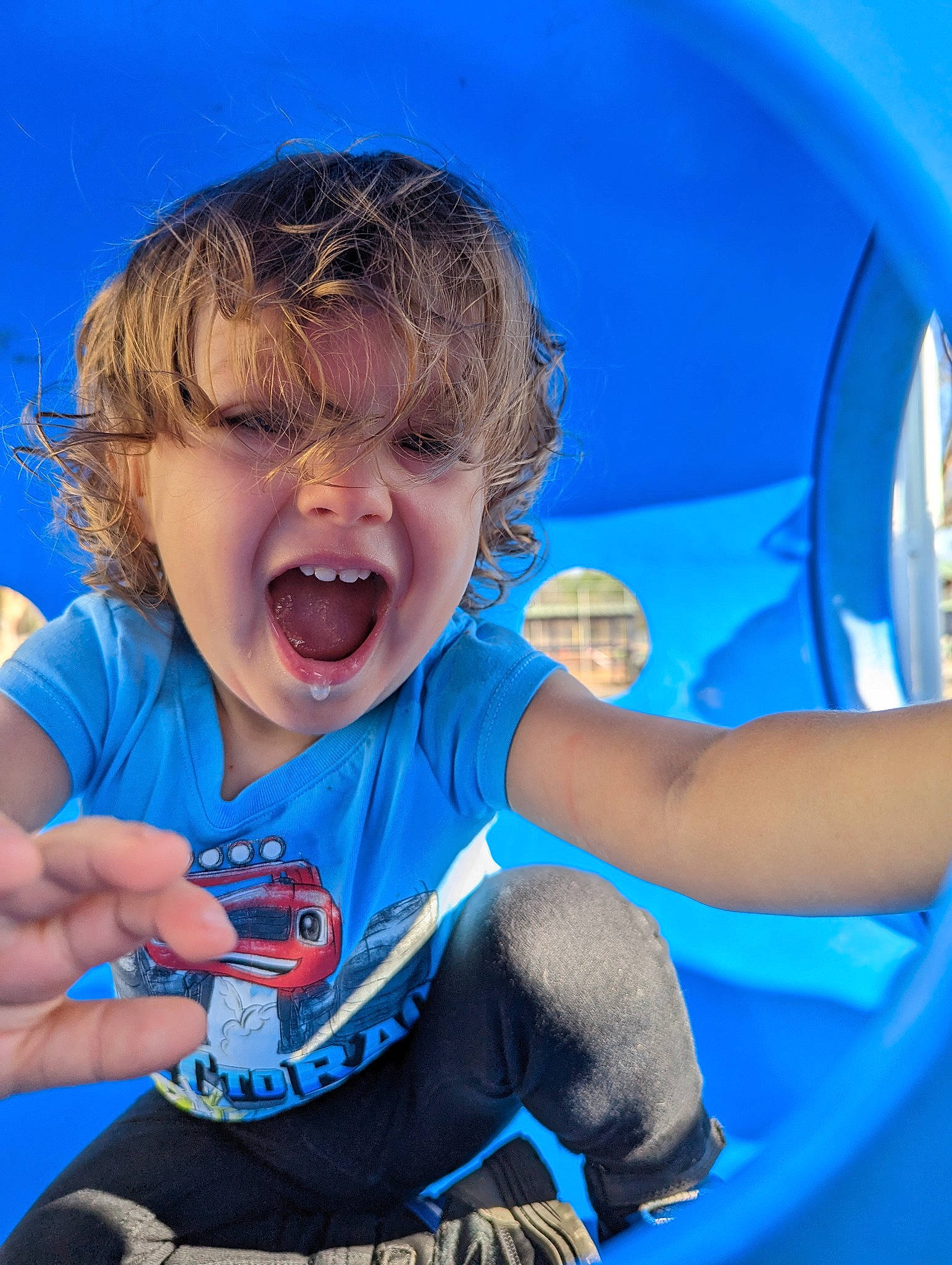 Drayce is registered to the contest to win money with this photo: automotive_exterior, azure, blue, bumper, child, electric_blue, fun, gesture, grass, happy, inflatable, laugh, leisure, outdoor_play_equipment, person, personal_protective_equipment, play, recreation, sitting, smile