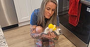 Mazzy Star is registered to the contest to win money with this photo: animal, bottle, cabinet, cute, feeding, floor, granite_countertop, home, indoor, kitchen, kitten, love, oven, pet_care, red_towel, sandals, small_pet, tattoo, woman, wood_floor