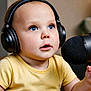 Elijah joined the competition — help win amazing prizes! child, toddler, headphones, microphone, table, yellow_shirt, blue_eyes, indoor, baby, face, curious, person, technology, recording, podcast, cute, expression, portrait, hands, listening