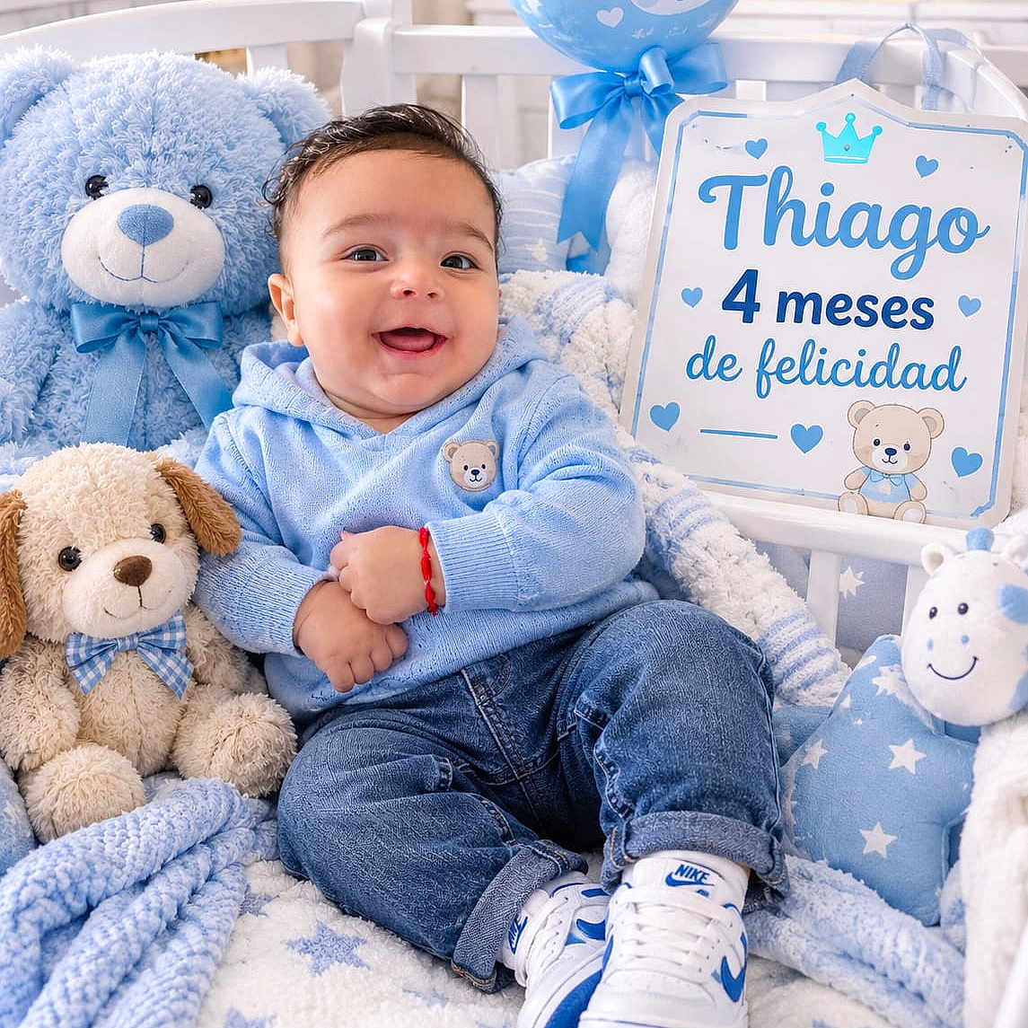 Thiago joined the competition — help win amazing prizes! baby, infant, child, smiling, sitting, portrait, blue_theme, teddy_bear, stuffed_animal, balloon, crib, blanket, plush_toy, baby_clothing, jeans, sneakers, nursery, birthday_sign, indoor, happy