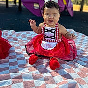Meredith is registered to the contest to win money with this photo: baby, child, smiling, outdoor, playground, blanket, dress, red, white, cute, happy, sitting, face, headwear, sock, person, photography, fun, infant, park