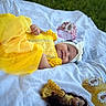 Meredith joined the competition — help win amazing prizes! baby, yellow_dress, headband, blanket, outdoor, grass, toy, doll, princess, smile, child, portrait, cute, playtime, accessories, happy, infant, lying_down, white, colorful