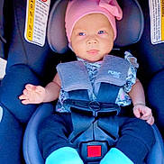 Charlee is registered to the contest to win money with this photo: baby, car_seat, pink_hat, blue_eyes, blue_socks, infant, child, seatbelt, safety, cute, portrait, clothing, indoor, young_child, expression, headwear, hands, footwear, straps, person