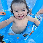 Chalom a rejoint le concours — aidez-le/la à gagner de superbes lots ! baby, child, smiling, pool, water, inflatable, float, blue, diaper, happy, wet_hair, summer, outdoor, play, fun, pirate_theme, person, cute, splash, joy