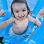baby, child, smiling, pool, water, inflatable, float, blue, diaper, happy, wet_hair, summer, outdoor, play, fun, pirate_theme, person, cute, splash, joy