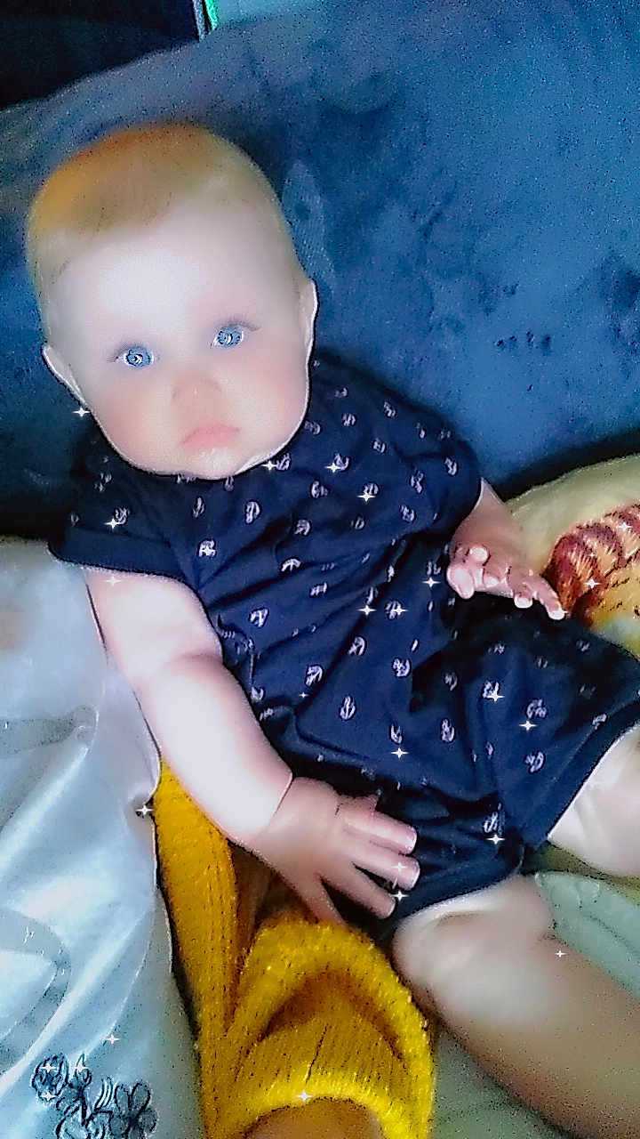 Kinsley participe au concours pour gagner de l'argent avec cette photo : baby, infant, blue_eyes, navy_outfit, anchors_pattern, blanket, cushion, hand, legs, face, indoor, soft_lighting, sparkle_effect, child, cute, sitting, plush, comfort, skin, young
