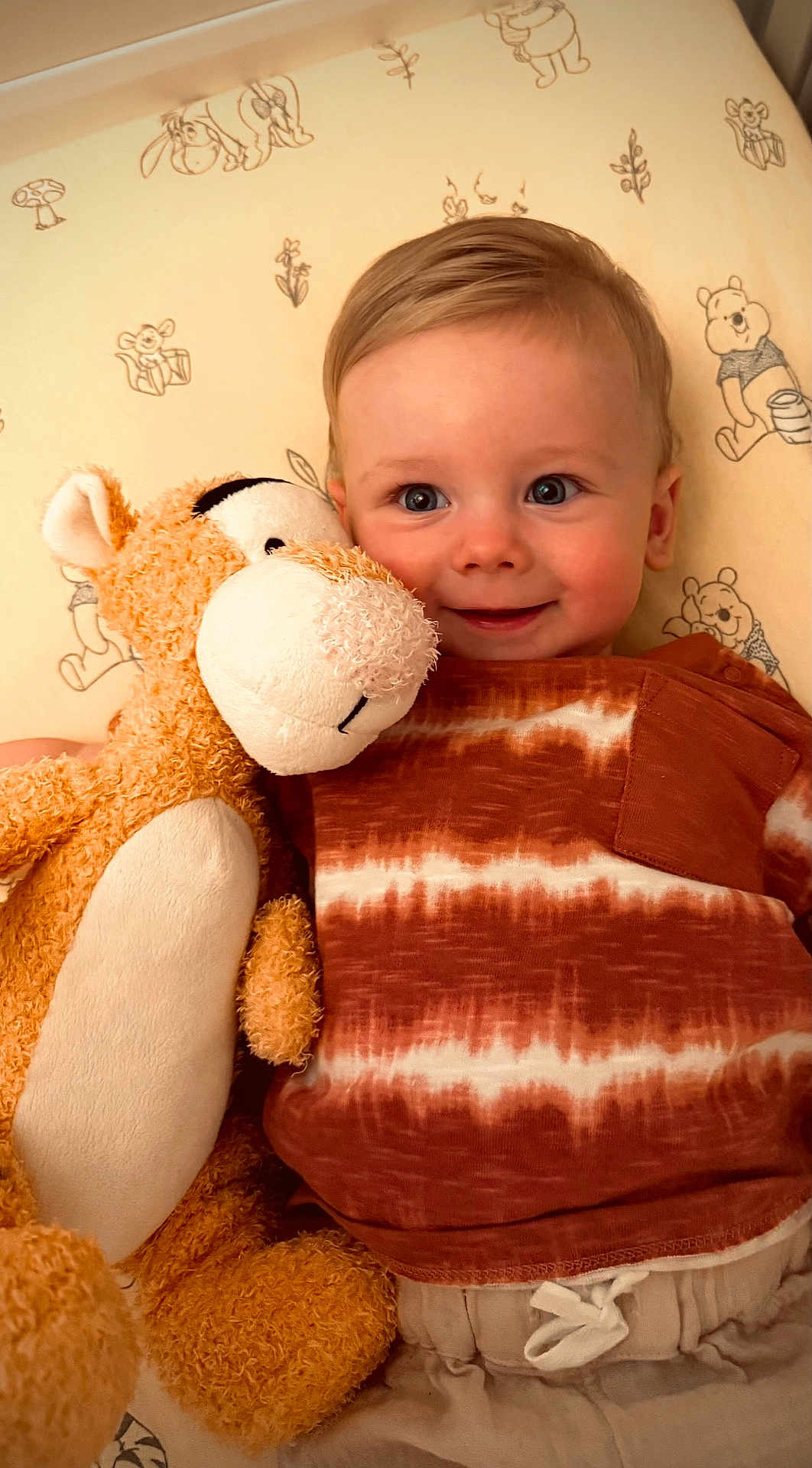 Arlo joined the competition — help win amazing prizes! toddler, child, stuffed_toy, tiger, smiling, bedspread, winnie_the_pooh, plush, orange, white, clothing, portrait, indoor, happy, cute, baby, cozy, soft_toy, playful, young