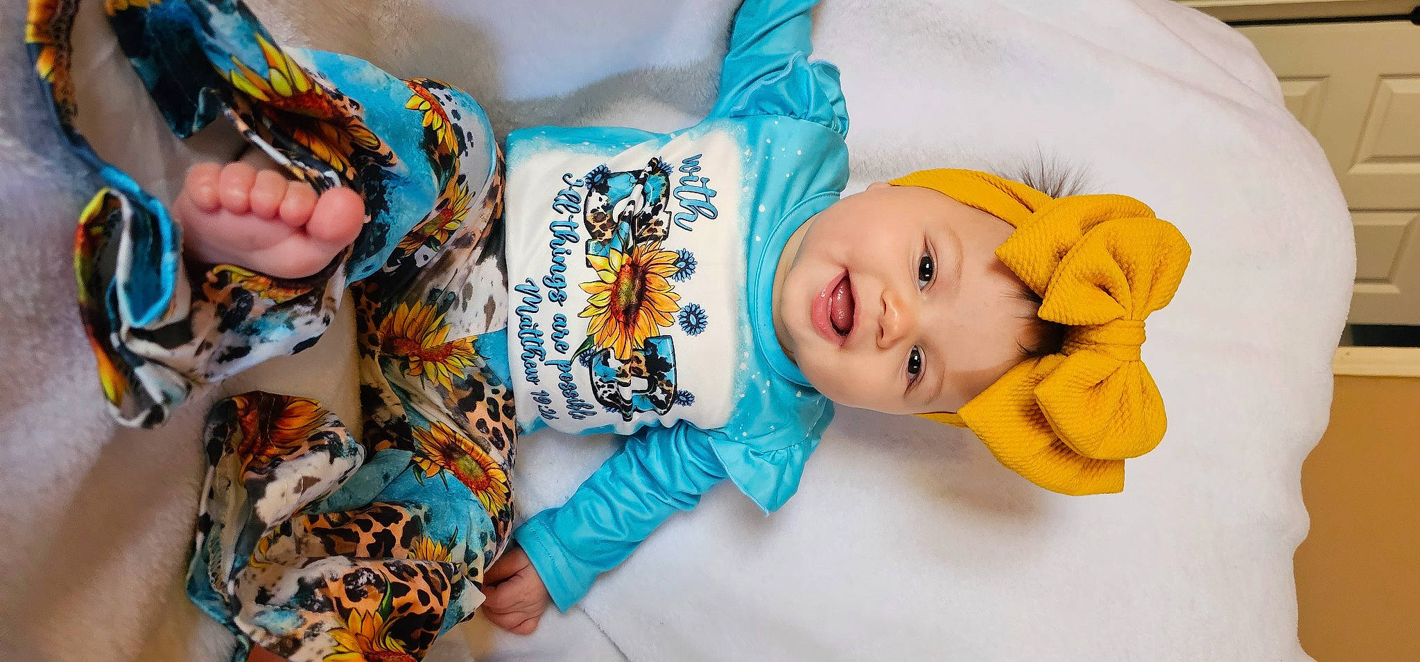 Stella is registered to the contest to win money with this photo: baby, baby_products, baby_toddler_clothing, child, fashion_accessory, finger, hand, happy, headwear, linens, orange, pattern, person, room, sleeve, smile, stuffed_toy, t_shirt, textile, toddler