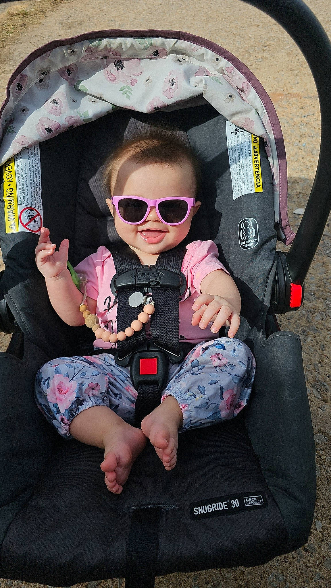 Stella is registered to the contest to win money with this photo: baby, baby_toddler_clothing, child, comfort, eyewear, fun, glasses, goggles, happy, lap, leisure, mouth, person, personal_protective_equipment, pink, recreation, sitting, sleeve, sunglasses, toddler