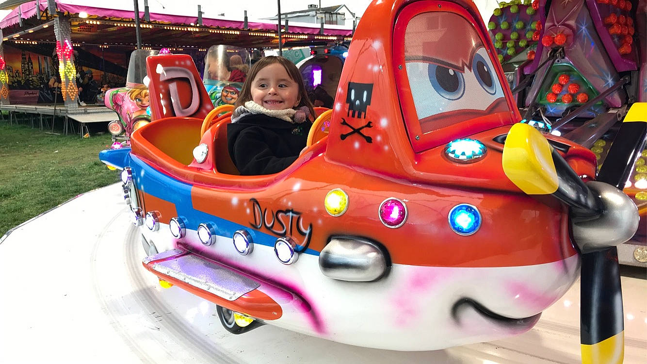 Lya a rejoint le concours — aidez-le/la à gagner de superbes lots ! amusement_ride, automotive_design, automotive_exterior, bumper, city, event, fun, headwear, joy, leisure, magenta, motor_vehicle, nonbuilding_structure, person, play, playground, recreation, smile, toddler, toy