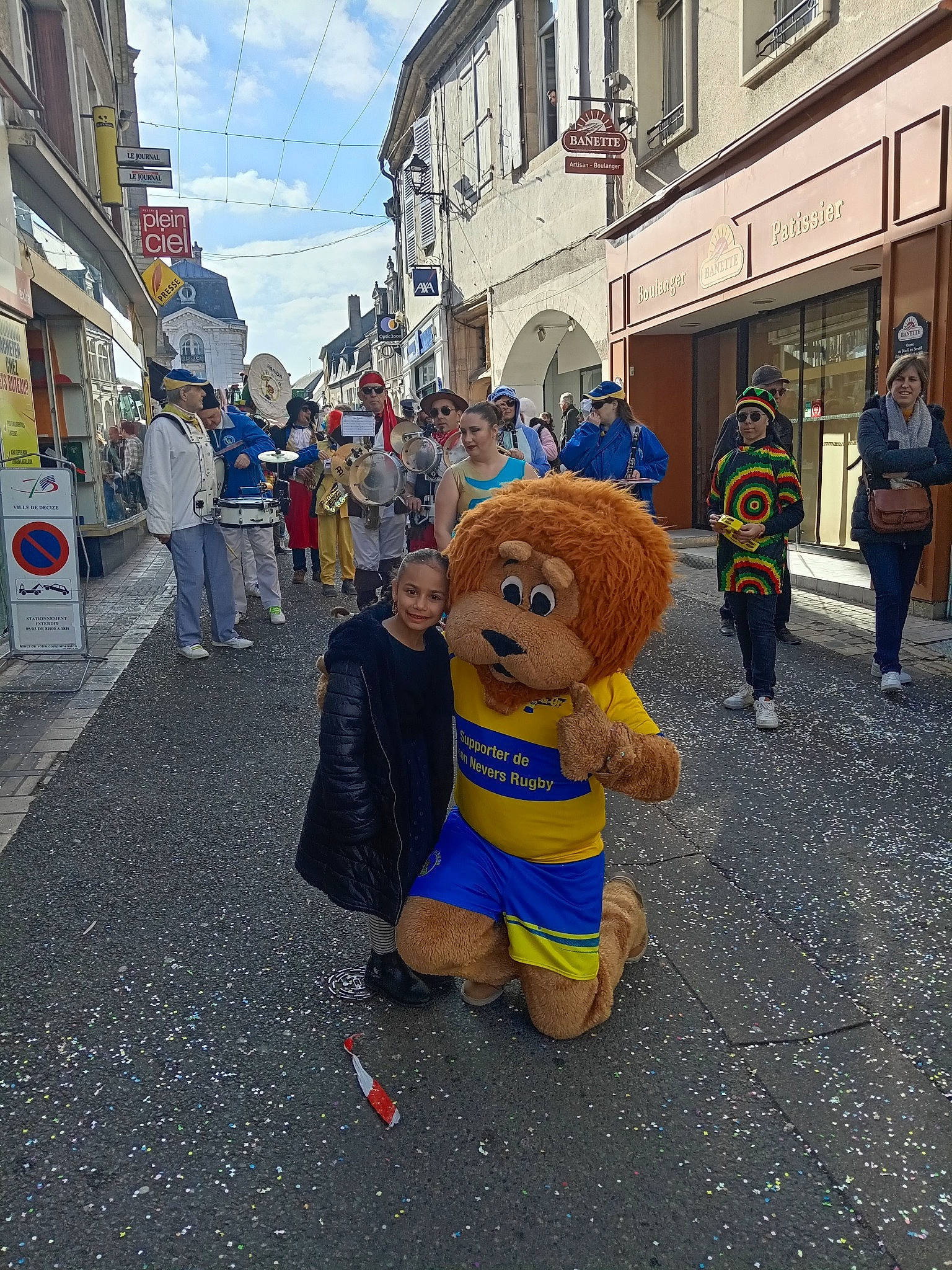 Fiona participe au concours pour gagner de l'argent avec cette photo : asphalt, building, city, cloud, crowd, event, fun, fur, hat, headwear, joy, leisure, mascot, pedestrian, person, public_event, recreation, road, road_surface, sky