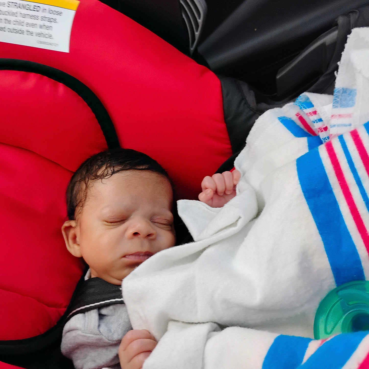 Santonio joined the competition — help win amazing prizes! baby, blanket, blue, car_interior, car_seat, child, cozy, cute, face, hands, indoors, infant, newborn, pacifier, peaceful, red, resting, sleeping, striped, white