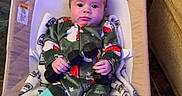 Andrew joined the competition — help win amazing prizes! baby, baby_rocker, blanket, book, child, colorful, cute, dumbbells, expression, face, floor, floor_tile, furniture, home, indoor, infant, pajamas, person, relaxing, toy