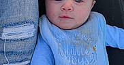 Andrew is registered to the contest to win money with this photo: baby, bib, blue_clothing, casual_wear, child, cute, denim, expression, face, hand, infant, lying_down, outdoor, person, portrait, ripped_jeans, shadow, skin, sunlight, young