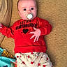 baby, pacifier, red_sweatshirt, heart_pattern, pants, couch, blanket, infant, cute, child, lying_down, clothing, face, person, home, indoors, socks, expression, comfort, soft_furniture