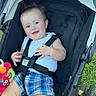 Andrew is registered to the contest to win money with this photo: baby, child, stroller, plaid_shorts, white_tank_top, toy, elmo, grass, outdoor, happy, smiling, blue_eyes, black_straps, safety_harness, pink_fan, sunny_day, cute, infant, casual_clothing, spiky_hair