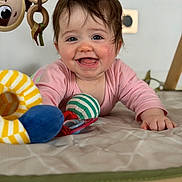 Ilinca a rejoint le concours — aidez-le/la à gagner de superbes lots ! baby, infant, smiling, play_mat, toy, soft_toy, colorful, child, indoors, happy, cute, face, hand, clothing, pink_shirt, crawling, expression, closeup, portrait, floor