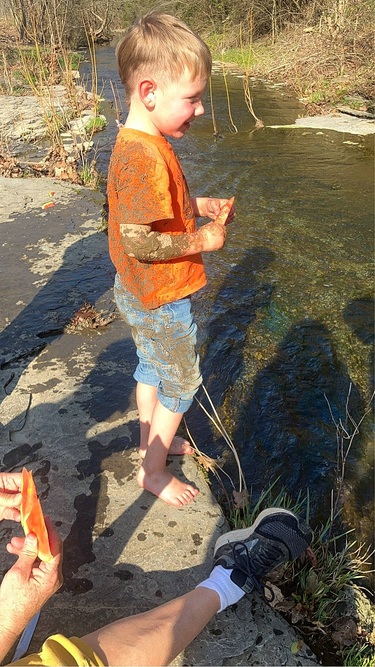 Cash is registered to the contest to win money with this photo: adaptation, barefoot, beach, body_of_water, fun, geology, grass, human_leg, landscape, leisure, people_in_nature, person, photograph, recreation, sand, shorts, soil, summer, t_shirt, toddler