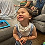 adult, bandana, casual, child, clothing, couch, family, furniture, happy, indoor, living_room, people, person, playful, shorts, sitting, smiling, tablet, toddler, wood_floor