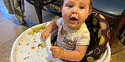 Phoenix joined the competition — help win amazing prizes! baby, high_chair, messy, food, face, child, meal, indoor, floor, shirt, expression, hands, vegetables, cute, infant, dining, happy, closeup, person, feeding