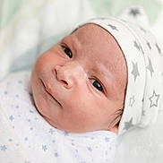 Grayson joined the competition — help win amazing prizes! baby, newborn, infant, face, hat, swaddled, blanket, stars, clothing, closeup, portrait, cute, sleeping_area, soft_light, indoor, child, newborn_hat, expression, person, head