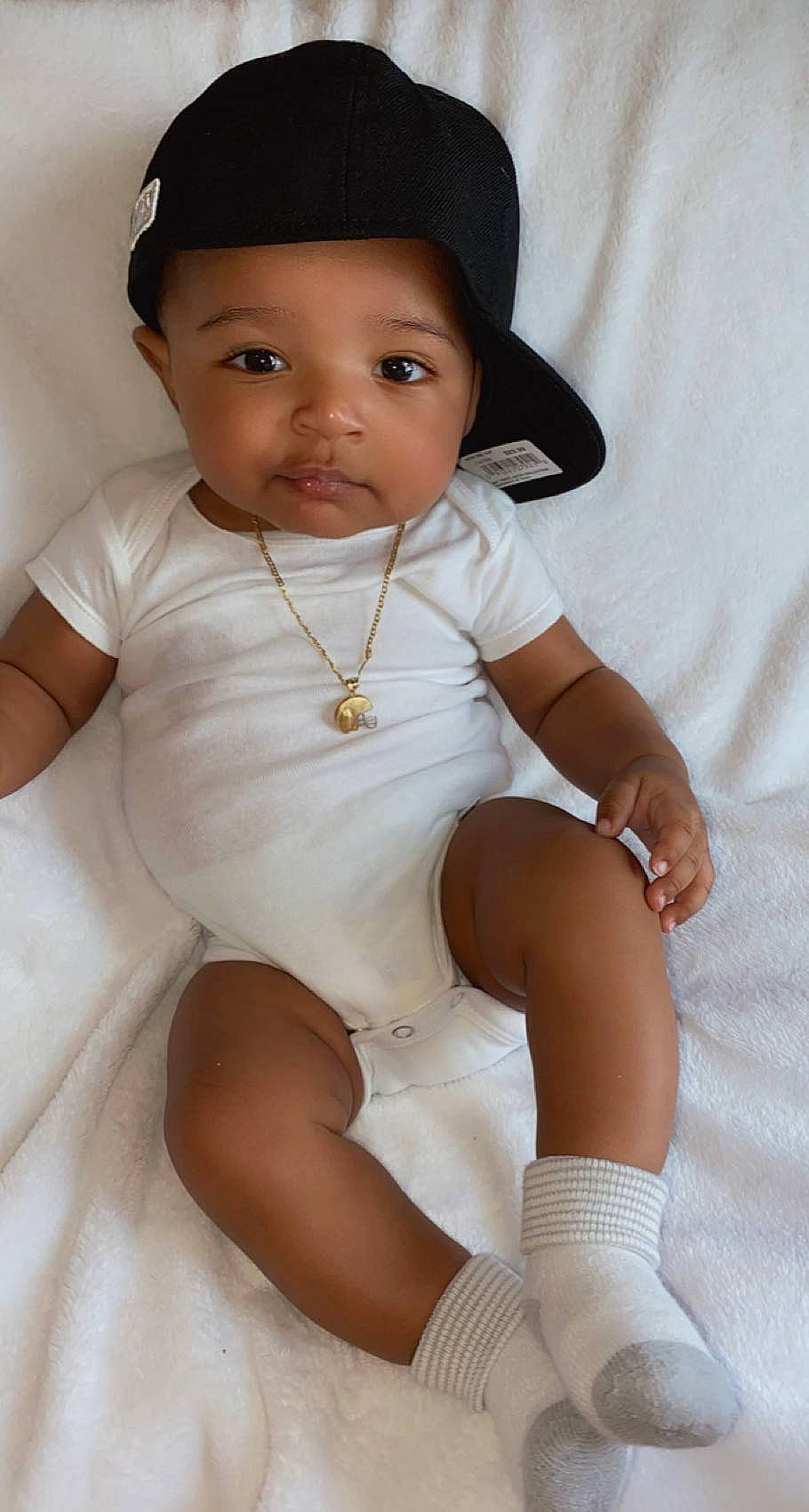 Jalen is registered to the contest to win money with this photo: baby, baby_toddler_clothing, cheek, chin, collar, comfort, eyelash, face, finger, hairstyle, hand, hat, headwear, knee, lip, neck, person, shoulder, skin, sleeve
