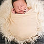 newborn, baby, sleeping, wrapped, blanket, fur, cushion, wooden_floor, peaceful, infant, portrait, soft_texture, cozy, cute, hands, face, closed_eyes, rest, indoor, warm