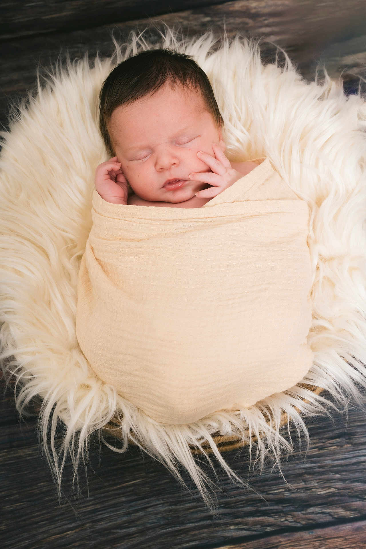 Lino participe au concours pour gagner de l'argent avec cette photo : newborn, baby, sleeping, wrapped, blanket, fur, cushion, wooden_floor, peaceful, infant, portrait, soft_texture, cozy, cute, hands, face, closed_eyes, rest, indoor, warm