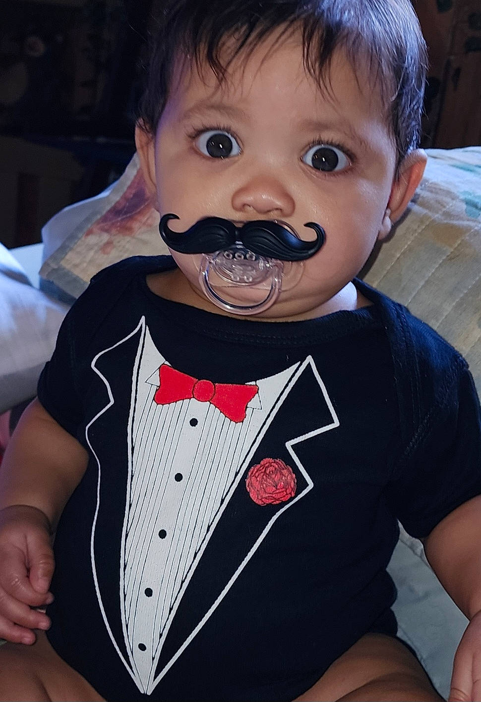 Kyla is registered to the contest to win money with this photo: baby, baby_toddler_clothing, bow_tie, cheek, child, cool, drinkware, event, eyelash, formal_wear, fun, gesture, hairstyle, happy, lip, moustache, pattern, person, sleeve, t_shirt