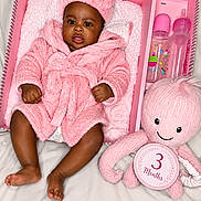 Jazaiyah is registered to the contest to win money with this photo: baby, blanket, bottle, box, child, cute, happy, headband, indoor, infant, newborn, octopus, pink, plush_toy, portrait, robe, smiling, soft_texture, three_months, toy