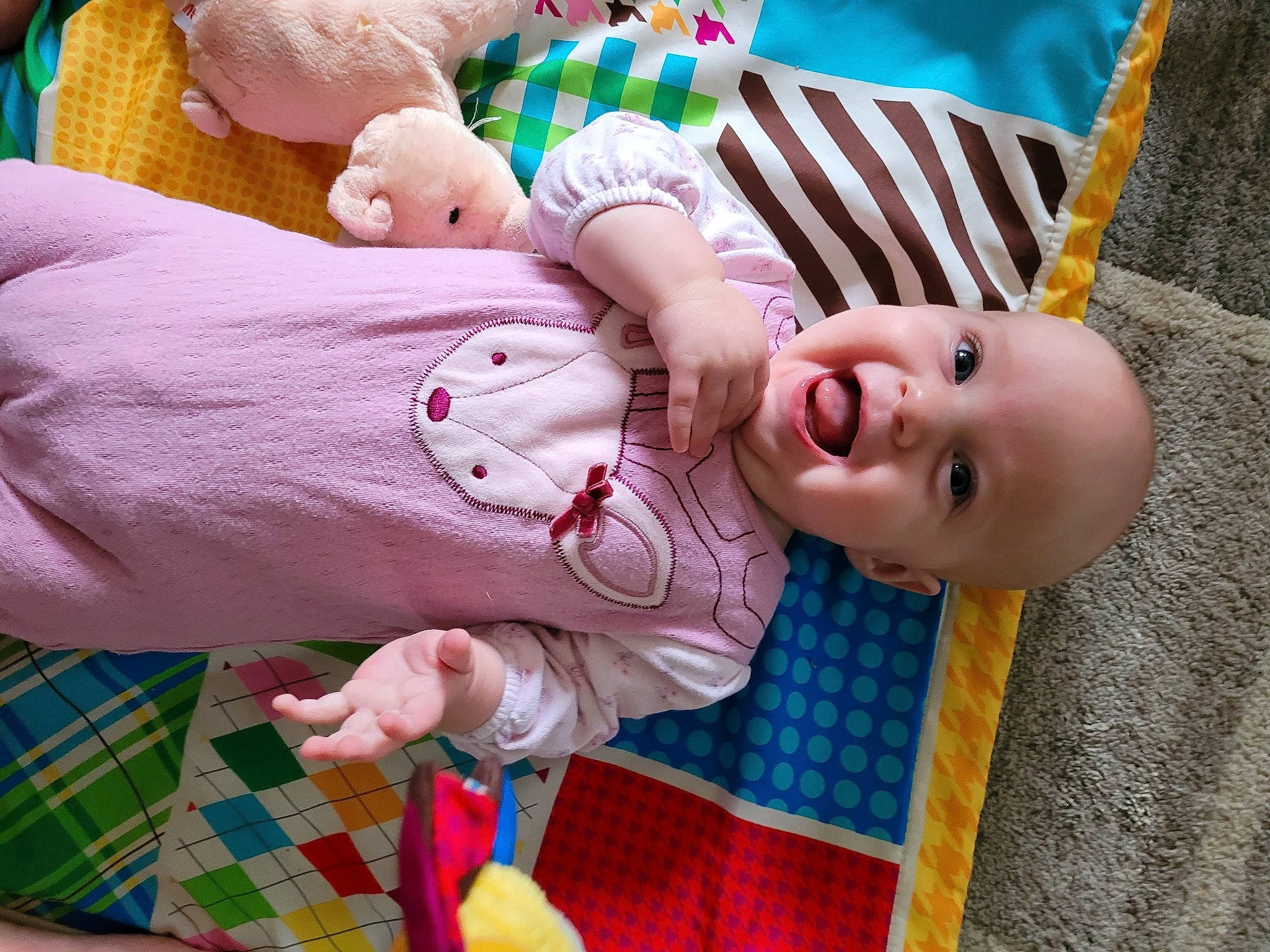 Aubrie is registered to the contest to win money with this photo: baby, baby_toddler_clothing, cheek, clothing, face, facial_expression, green, hand, mammal, mouth, nose, organ, person, photograph, pink, product, skin, smile, tartan, textile