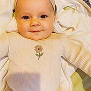 éva participe au concours pour gagner de l'argent avec cette photo : baby, infant, headband, smile, face, clothing, blanket, cute, portrait, lying_down, happy, child, soft, indoors, apparel, person, closeup, baby_girl, fabric, cozy