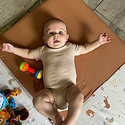 Livio participe au concours pour gagner de l'argent avec cette photo : animal_print, arms_spread, baby, child, colorful, cute, face, floor_mat, flooring, happy, indoor, infant, legs_spread, lying_down, onesie, patterned_mat, person, playtime, smiling, toy