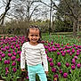 Avianna is registered to the contest to win money with this photo: child, clothing, face, female, flower, footwear, grass, head, nature, outdoors, pants, park, person, petal, photography, plant, portrait, purple, shoe, vegetation