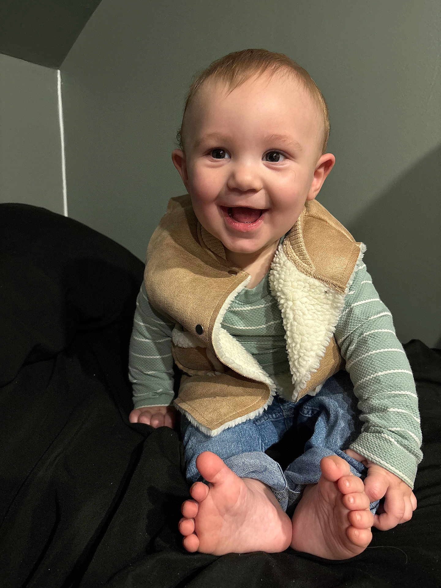 Liam joined the competition — help win amazing prizes! baby, child, smiling, happy, sitting, feet, toes, vest, clothing, jeans, long_sleeve, striped, indoor, person, cute, face, head, skin, fingers, cozy
