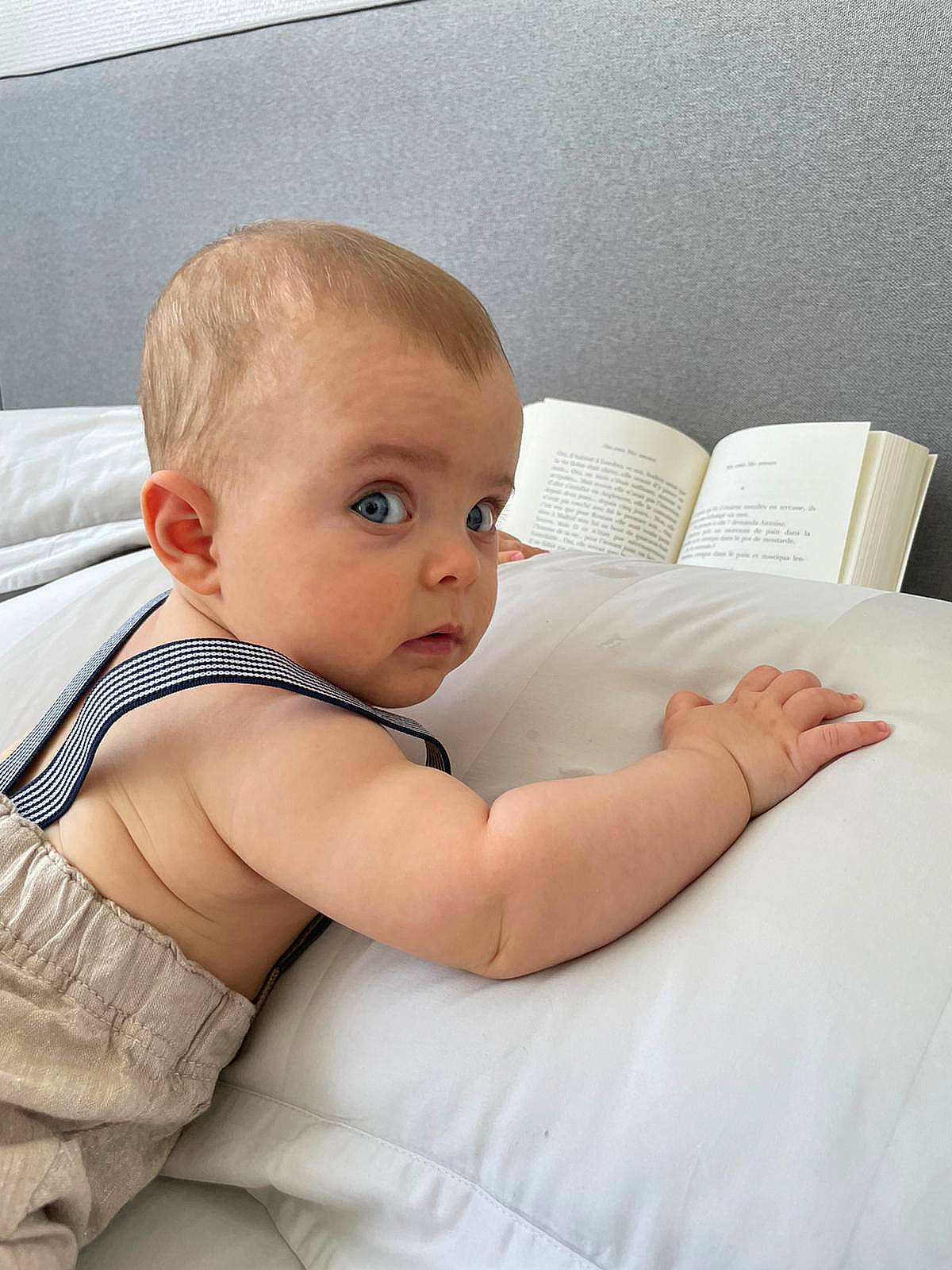 Aaron participe au concours pour gagner de l'argent avec cette photo : abdomen, baby, baby_toddler_clothing, book, chest, child, comfort, couch, elbow, finger, gesture, happy, human_body, human_leg, joint, person, room, shoulder, sitting, surprise