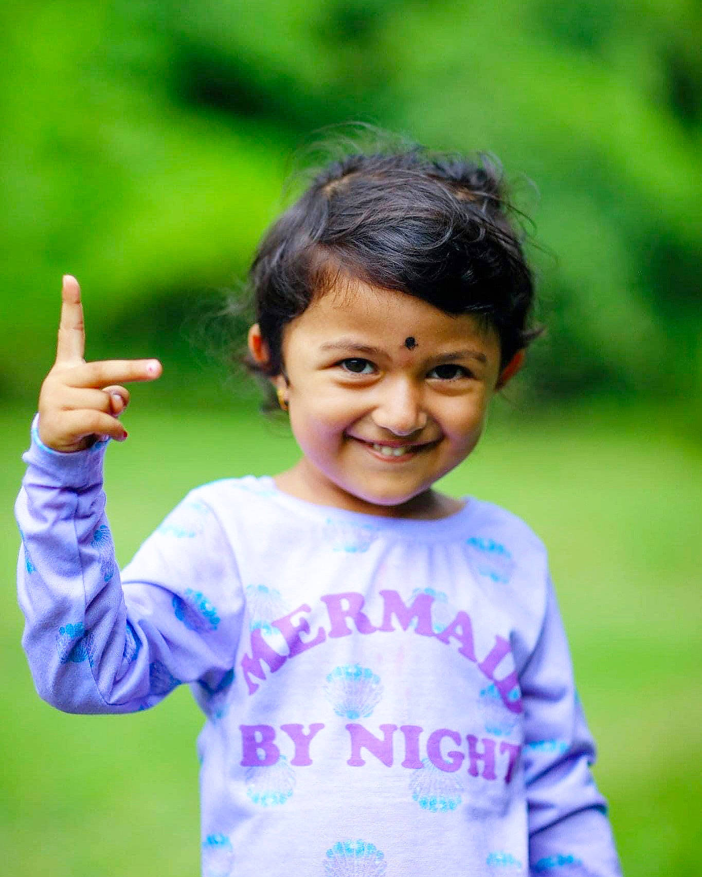 Sophia is registered to the contest to win money with this photo: child, electric_blue, fun, gesture, grass, grassland, hand, happy, joy, leisure, nature, people_in_nature, person, plant, recreation, skin, sleeve, smile, t_shirt, thumb