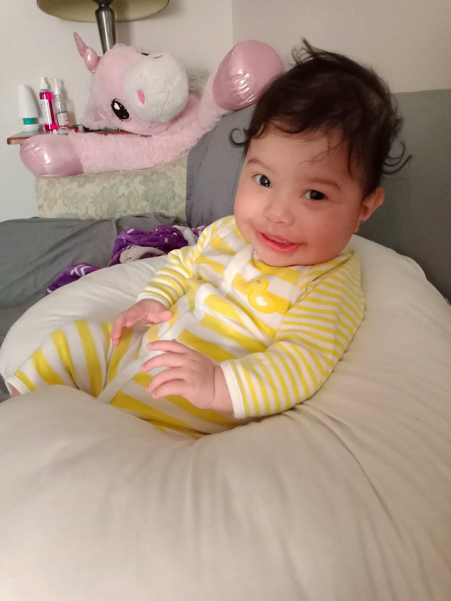 Alita is registered to the contest to win money with this photo: baby, baby_toddler_clothing, bedding, cheek, child, comfort, fun, happy, head, joy, linens, mammal, nose, person, pink, room, skin, smile, t_shirt, textile