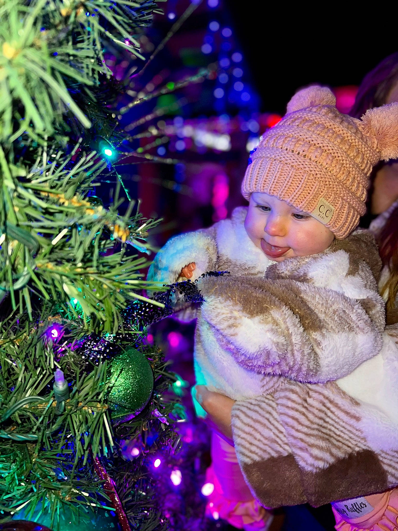 Lucy joined the competition — help win amazing prizes! cap, christmas, christmas_decoration, christmas_eve, christmas_ornament, christmas_tree, electric_blue, event, evergreen, fun, headwear, holiday, holiday_ornament, light, ornament, person, plant, purple, toddler, tradition